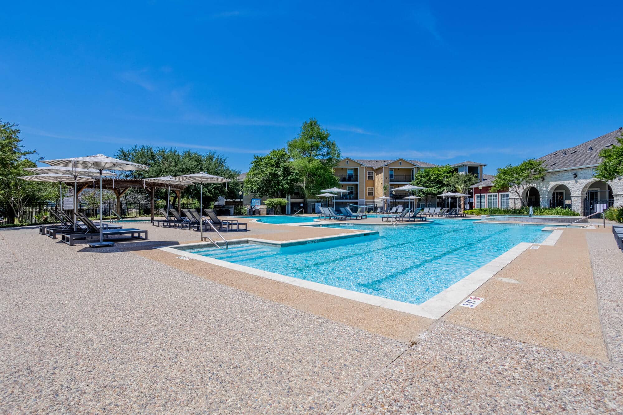university trails college station off campus apartments near texas a m resort style pool with lounge seating